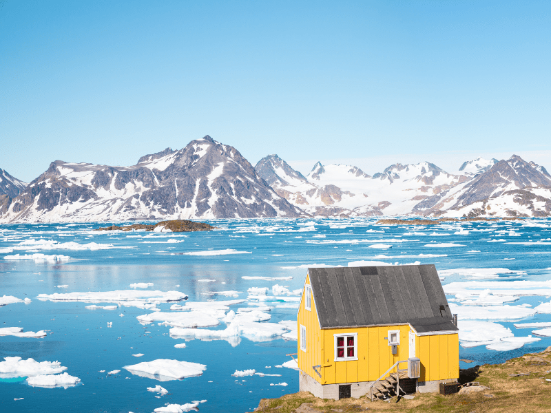 Yellow house looking over ice fields and the ocean in Greenland 